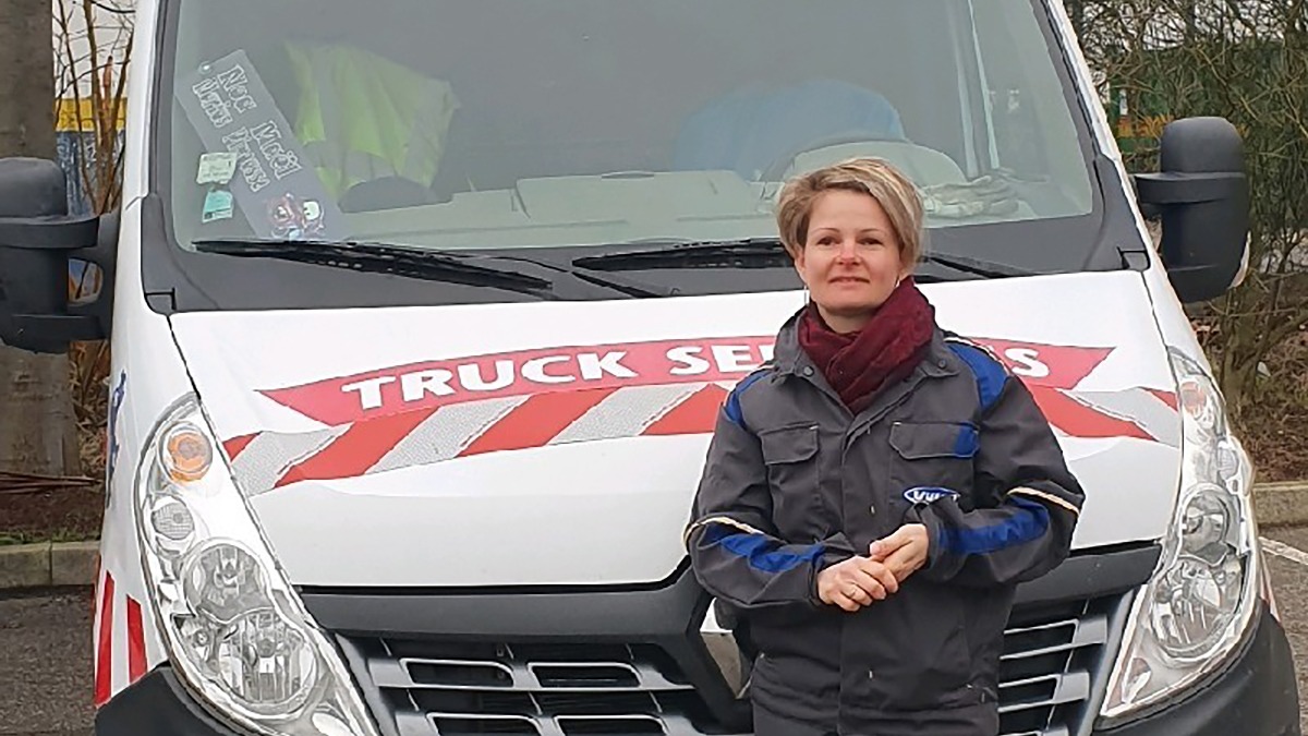 photo d'une femme mécanicienne en bleu de travail devant une camionnette